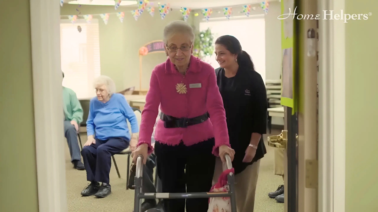 Caregiver assisting senior woman based on her level of care in assisted living.