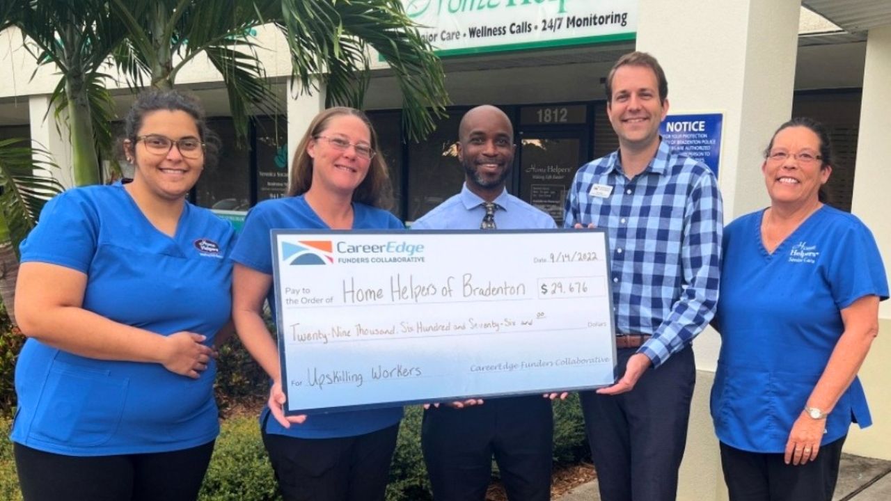 Home helpers team Jonathan and the admin staff with CareerEdge representative holding the big check