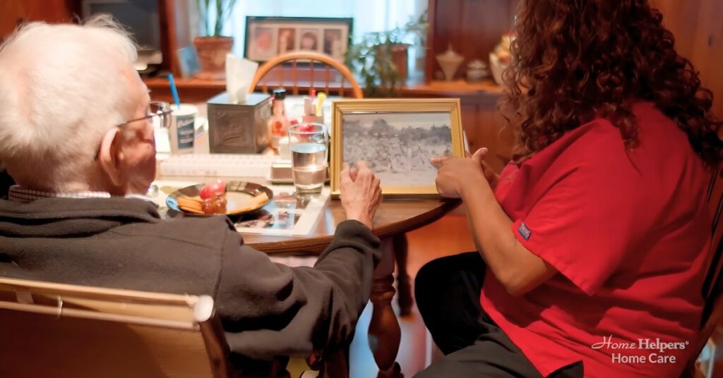 An elderly veteran showing a photo to his home health aide