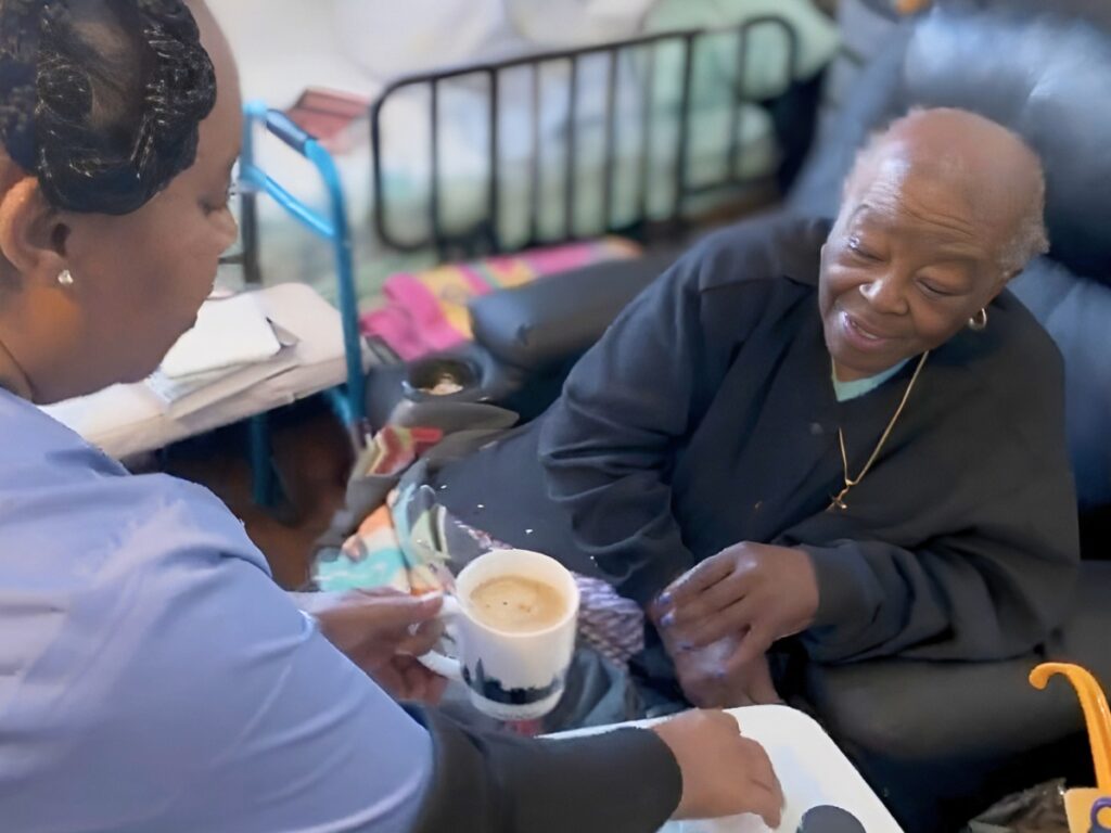 Caregiver giving coffee to senior client