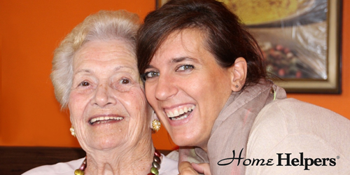 Caregiver with female senior smiling together.