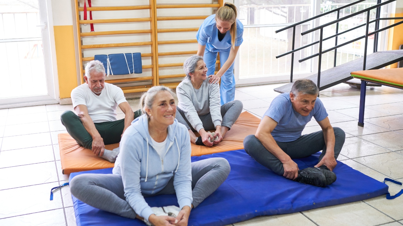 Professional assisting yoga for seniors.