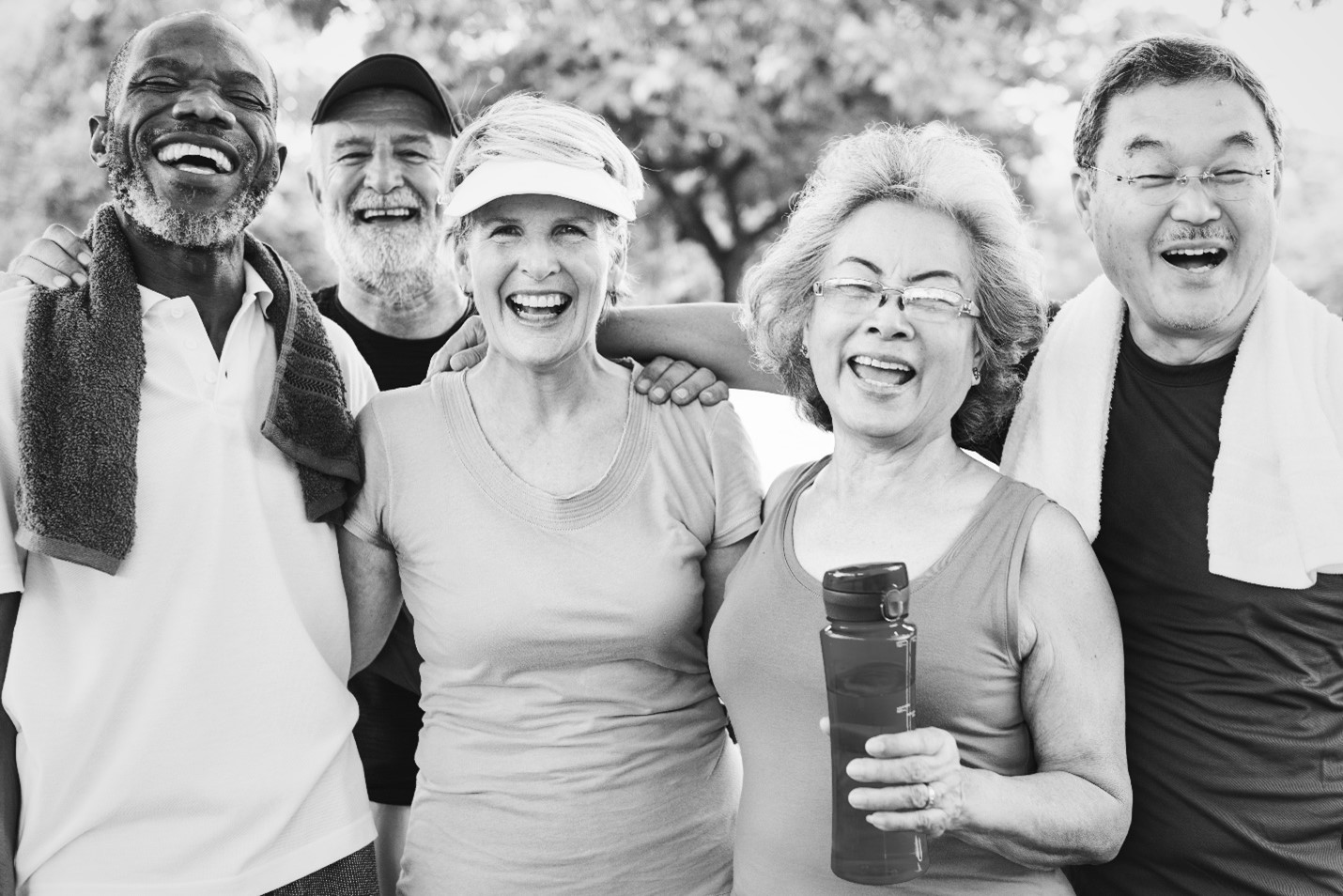 Group of diverse male and female seniors exercising and laughing together.