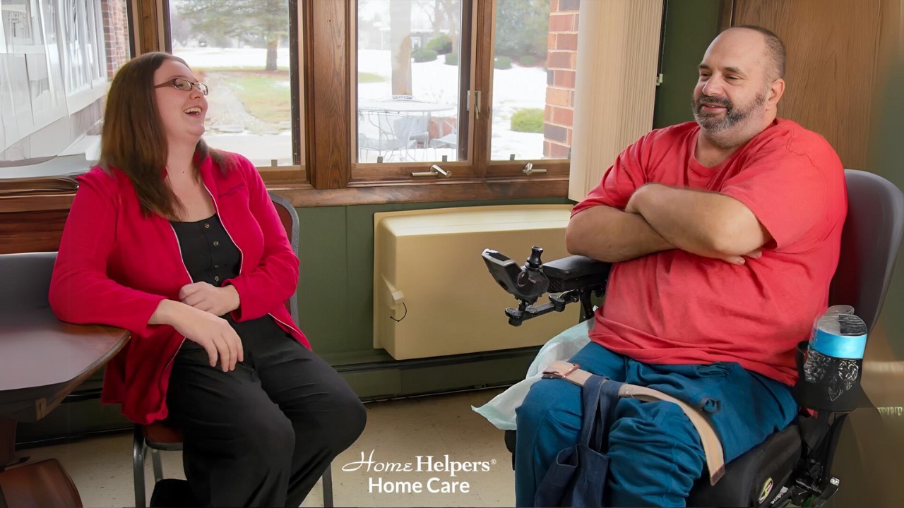 Home health aide and person in wheelchair having fun during companion care services.