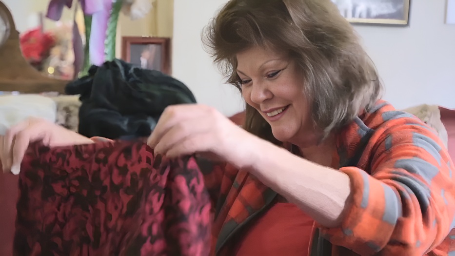 Caregiver smiling while folding clothes