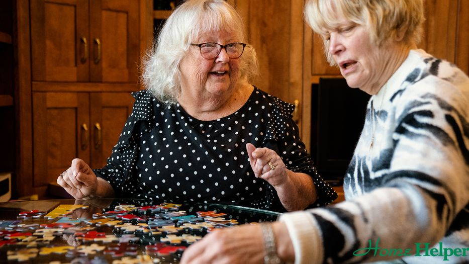 Senior woman and a Home Helpers caregiver playing Jigsaw Puzzles.