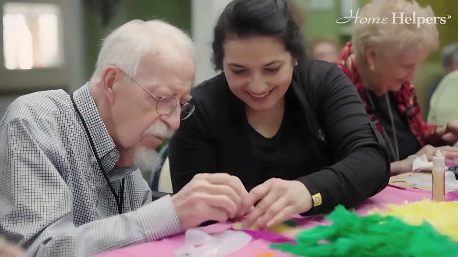 Home Helpers caregiver and his male senior client joined community event arts and crafts.