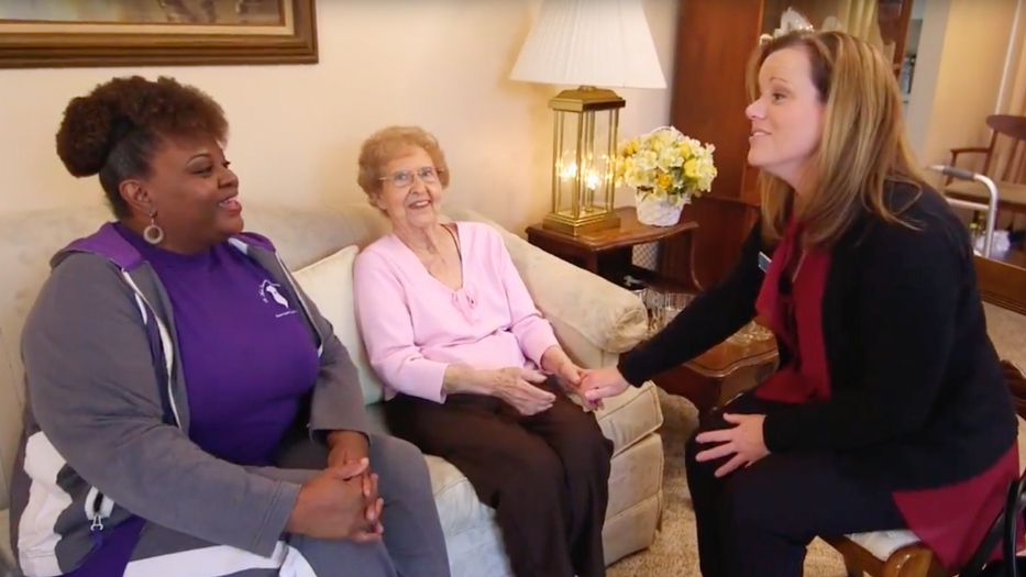 Senior woman meeting caregiver and Home Helpers admin.