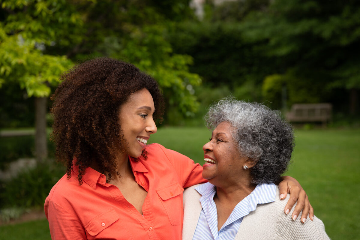 Side view of senior hugging family member