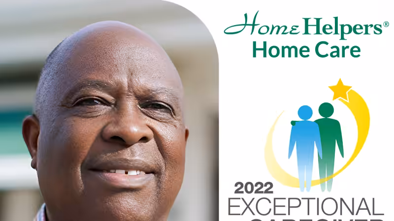 Smiling man in front of a blurred background with Home Helpers Home Care logo and 2022 Exceptional Caregiver award graphic featuring two figures and a gold star.