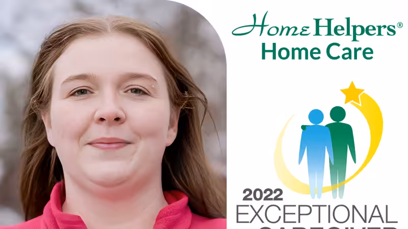 A woman with light skin and long brown hair stands outdoors, wearing a pink shirt. Next to her is the Home Helpers Home Care logo and a 2022 Exceptional Caregiver award graphic with two figures and a gold star.