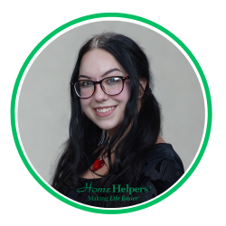 A smiling woman with long dark hair and glasses, wearing a black top and a red necklace, is shown in a circular frame with a green border. The words “Home Helpers Making Life Easier” appear at the bottom.
