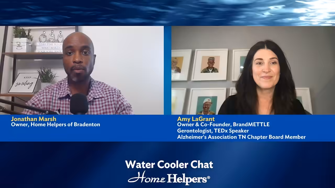 Two people speak in a split-screen video chat titled Water Cooler Chat Home Helpers. Text identifies Jonathan Marsh, Owner of Home Helpers of Bradenton, and Amy LaGrant, gerontologist and Alzheimers Association board member.