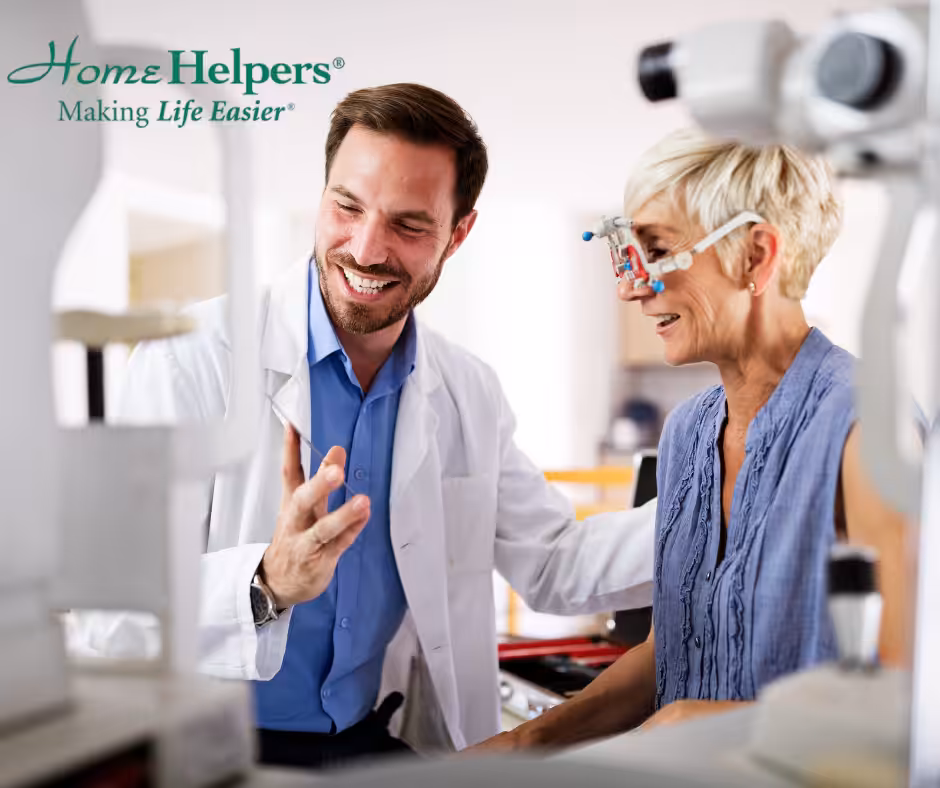 A male optometrist smiles and gestures while assisting an older woman wearing eye exam equipment in a clinic. The Home Helpers logo and slogan appear in the top left corner.