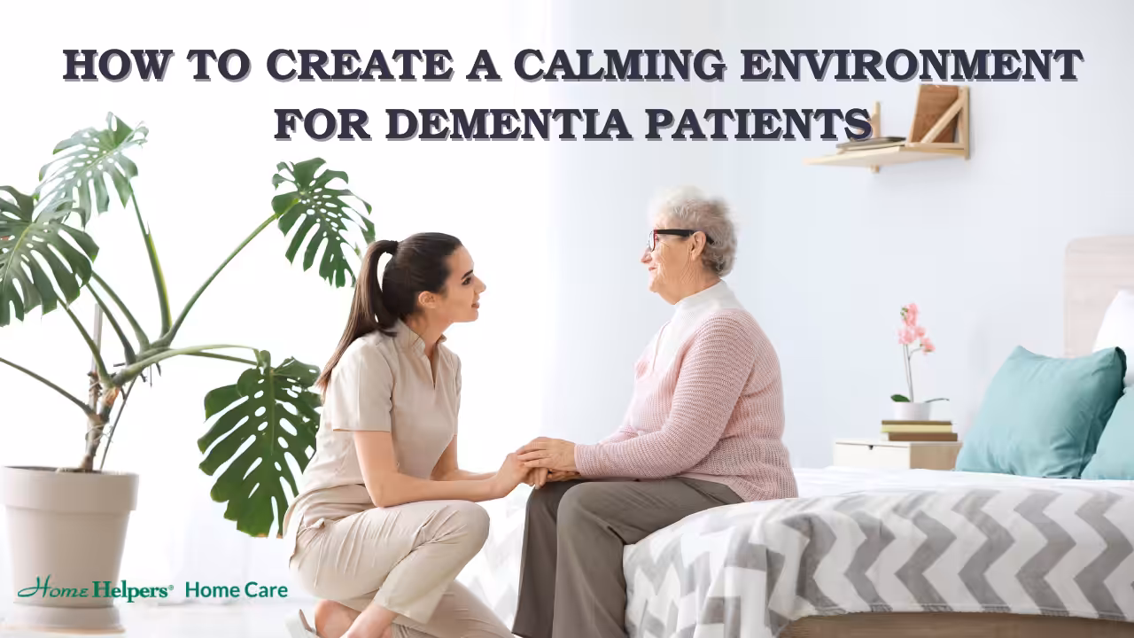 A caregiver kneels and holds hands with an elderly woman sitting on a bed in a bright, tidy bedroom. Text reads, How to create a calming environment for dementia patients.