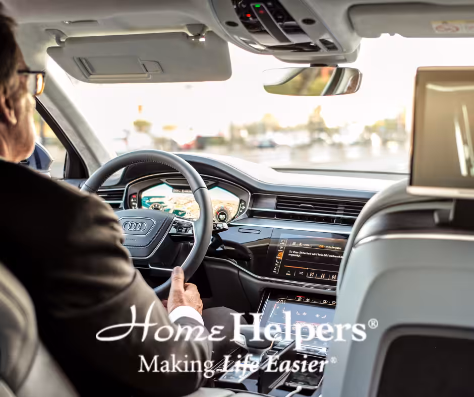 A person in a suit drives a modern Audi car, seen from the back seat. The dashboard displays digital controls. The logo Home Helpers: Making Life Easier is overlaid on the image.