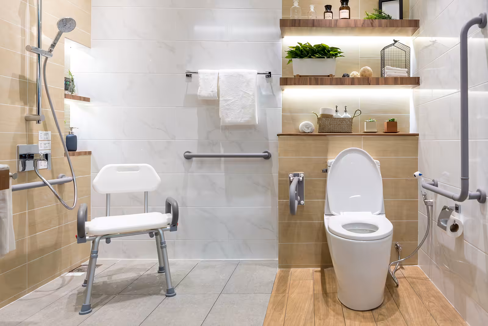 An accessible bathroom with a shower chair, grab bars, toilet, shelves with plants and toiletries, towels, and a handheld showerhead, designed for safety and ease of use.
