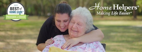 A smiling caregiver hugs an older woman from behind outdoors. A “2017 Best of Home Care Provider of Choice” badge and “Home Helpers: Making Life Easier” logo are displayed on the image.
