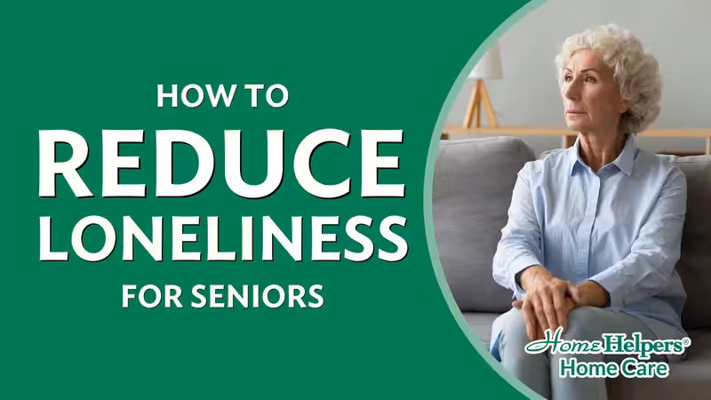 A senior woman with curly white hair sits alone on a couch, looking thoughtful. Text reads How to Reduce Loneliness for Seniors. Home Helpers Home Care logo is in the corner.