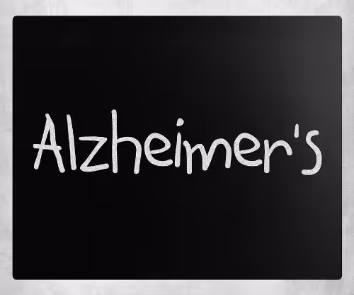 The word Alzheimers is written in white chalk-like letters on a black chalkboard background.