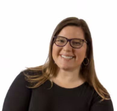 A woman with long brown hair, wearing glasses and a black top, smiles at the camera against a plain white background.