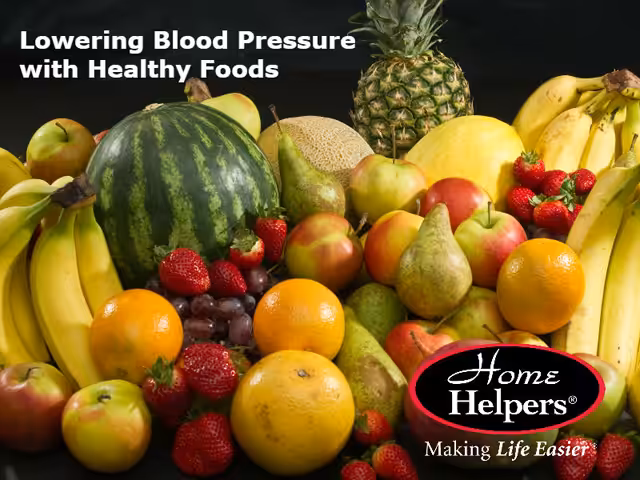 A colorful assortment of fresh fruit, including bananas, watermelon, pineapple, oranges, pears, apples, and strawberries, with the text Lowering Blood Pressure with Healthy Foods and the Home Helpers logo.
