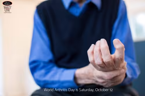 A person in a blue shirt and dark vest holds their painful wrist. Text at the bottom reads, World Arthritis Day is Saturday, October 12.