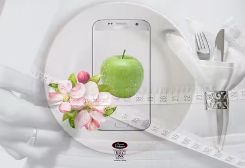 A white plate with a smartphone displaying a green apple, next to a napkin with cutlery. A measuring tape, a pink flower, and an outline of a person’s waist are overlaid on the image.
