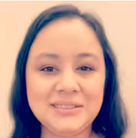 A woman with long dark hair is smiling gently at the camera. She is standing in front of a plain, light-colored background.