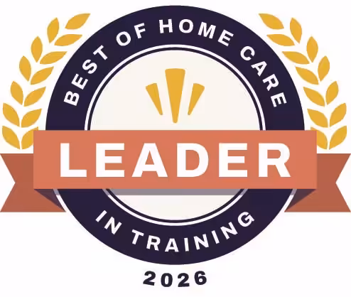 A circular badge with a laurel design, reading Best of Home Care - Leader in Training 2026 with Leader highlighted in white on an orange banner across the center.