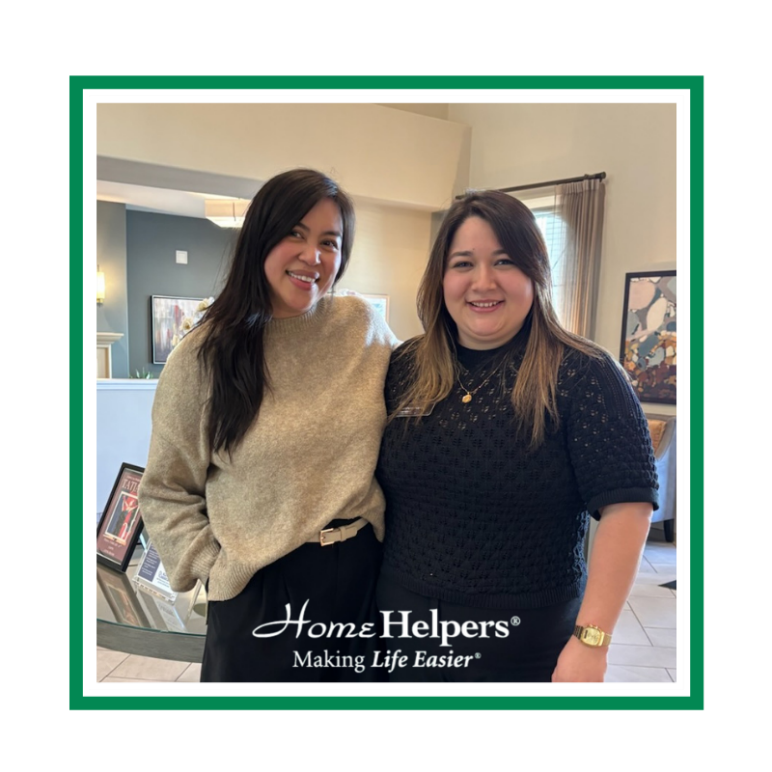 Two women smiling and standing side by side indoors, with a Home Helpers® logo and the phrase “Making Life Easier®” at the bottom. The image has a green and white border.