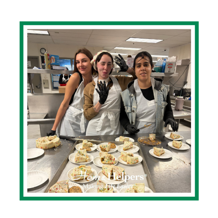 Three women wearing aprons and gloves stand together in a kitchen, smiling at the camera behind a counter filled with plates of cake slices. The text Tonys Helpers appears at the bottom of the image.