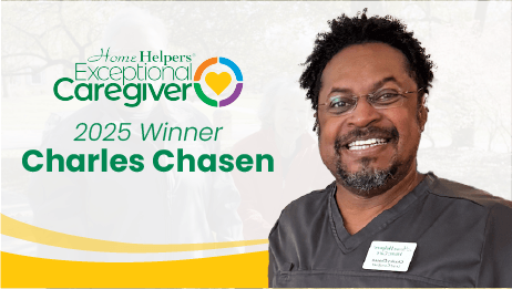 A smiling man in scrubs stands next to text that reads Home Helpers Exceptional Caregiver 2025 Winner Charles Chasen. A colorful heart logo is above the text.