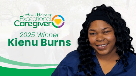 A smiling woman in navy scrubs is featured next to text reading Home Helpers Exceptional Caregiver, 2025 Winner Kienu Burns with a colorful heart logo in the background.
