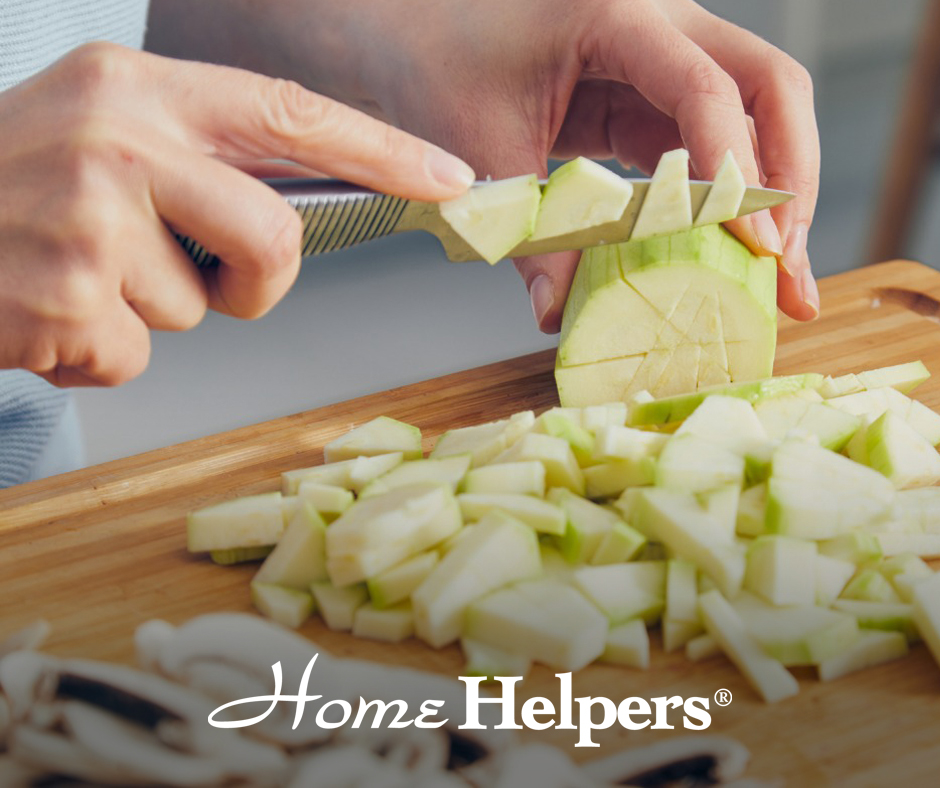 A person chops a green apple on a wooden cutting board with a knife. Diced apple pieces and sliced mushrooms are visible; Home Helpers text is at the bottom.