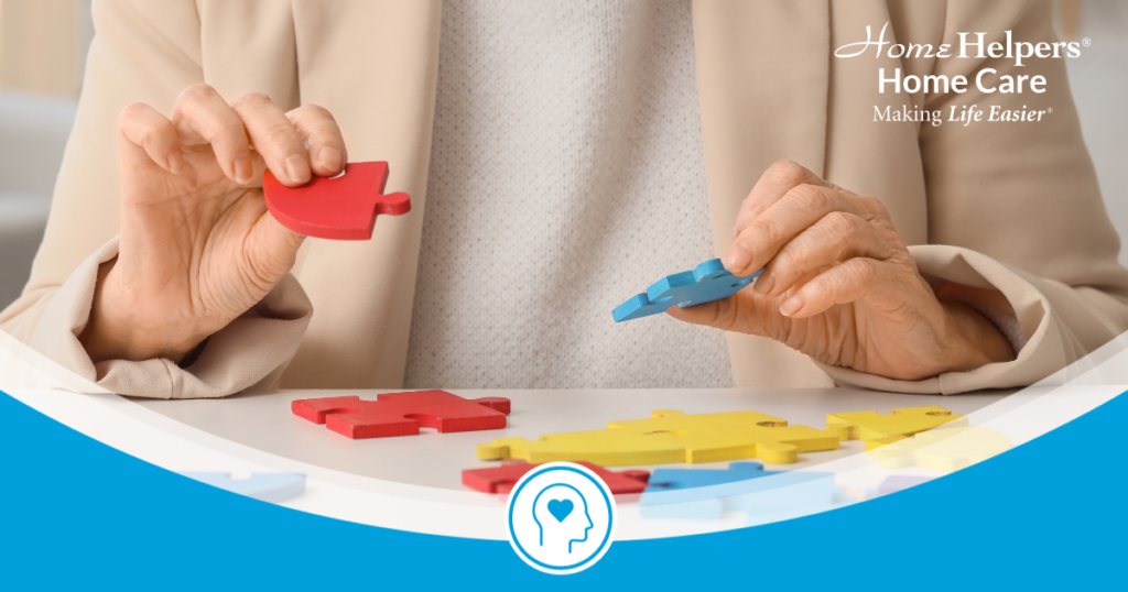 A person assembles colorful puzzle pieces on a table. The image features a Home Helpers Home Care logo in the corner.